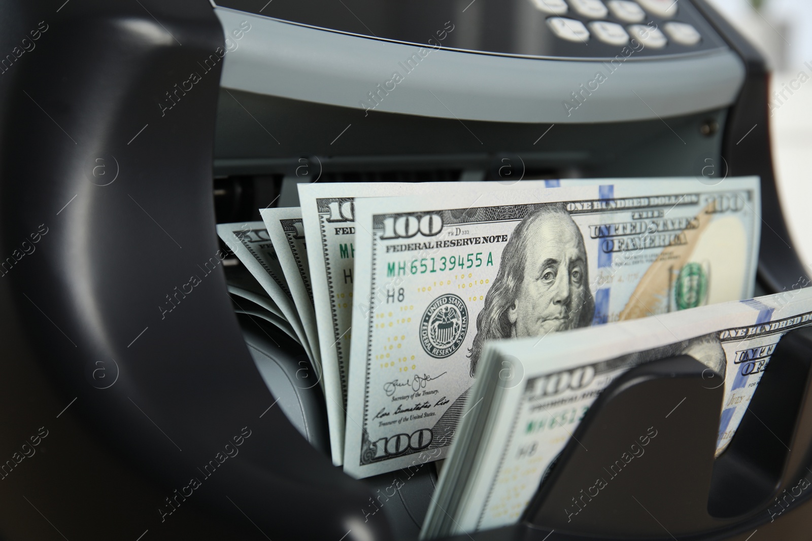 Photo of Modern electronic bill counter with money, closeup