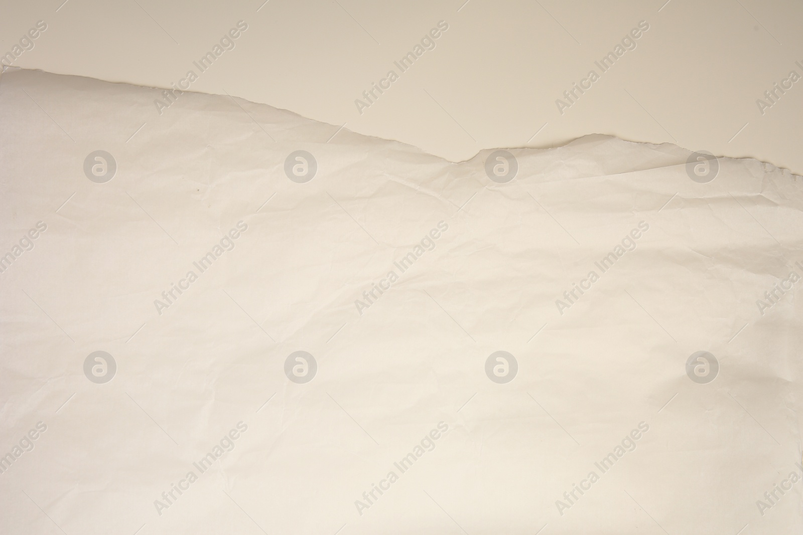 Photo of Parchment paper with torn edge on beige background, top view