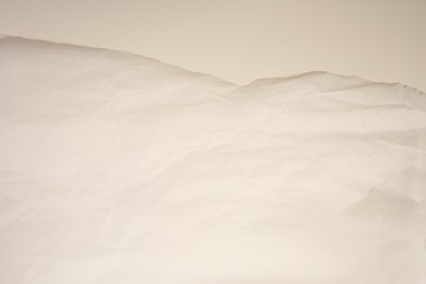 Photo of Parchment paper with torn edge on beige background, top view