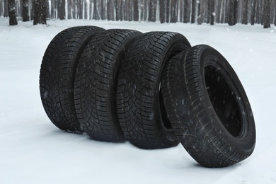 Photo of New winter tires on fresh snow near forest