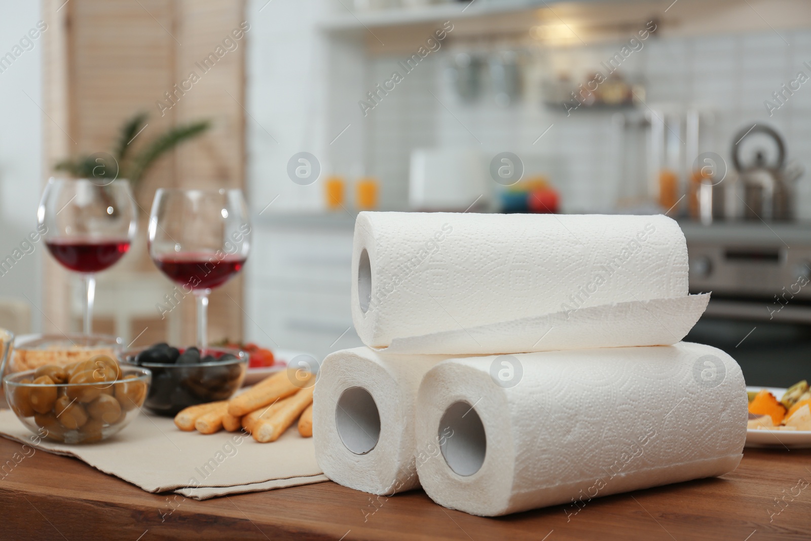 Photo of Rolls of paper towels on table in kitchen, space for text