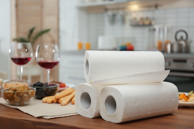 Photo of Rolls of paper towels on table in kitchen, space for text