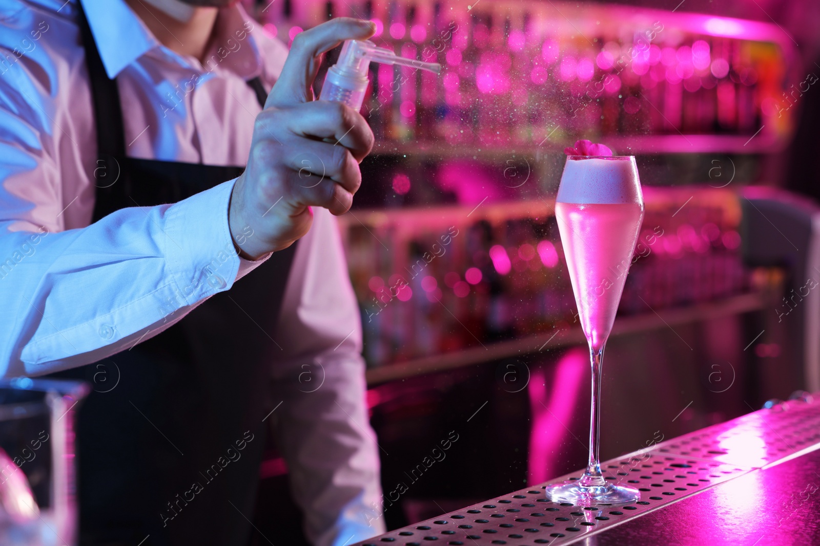 Photo of Bartender making fresh alcoholic cocktail at counter in bar, closeup