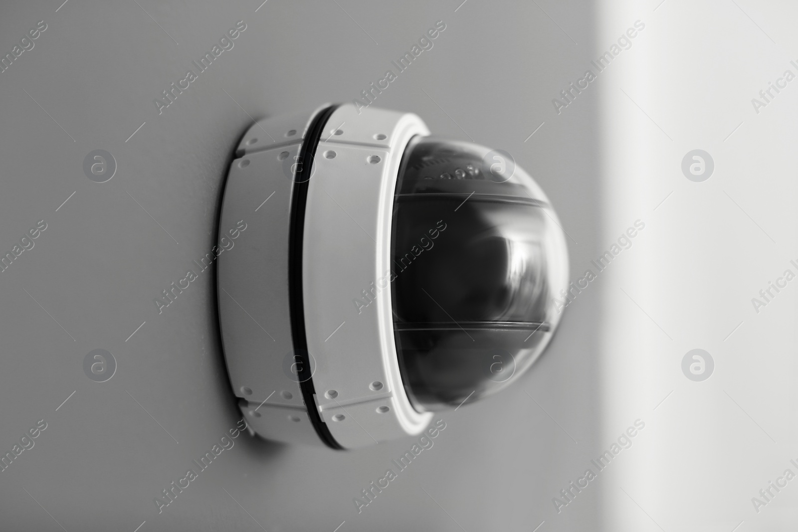 Photo of Modern security CCTV camera on grey wall