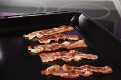 Slices of tasty fried bacon on kitchen stove