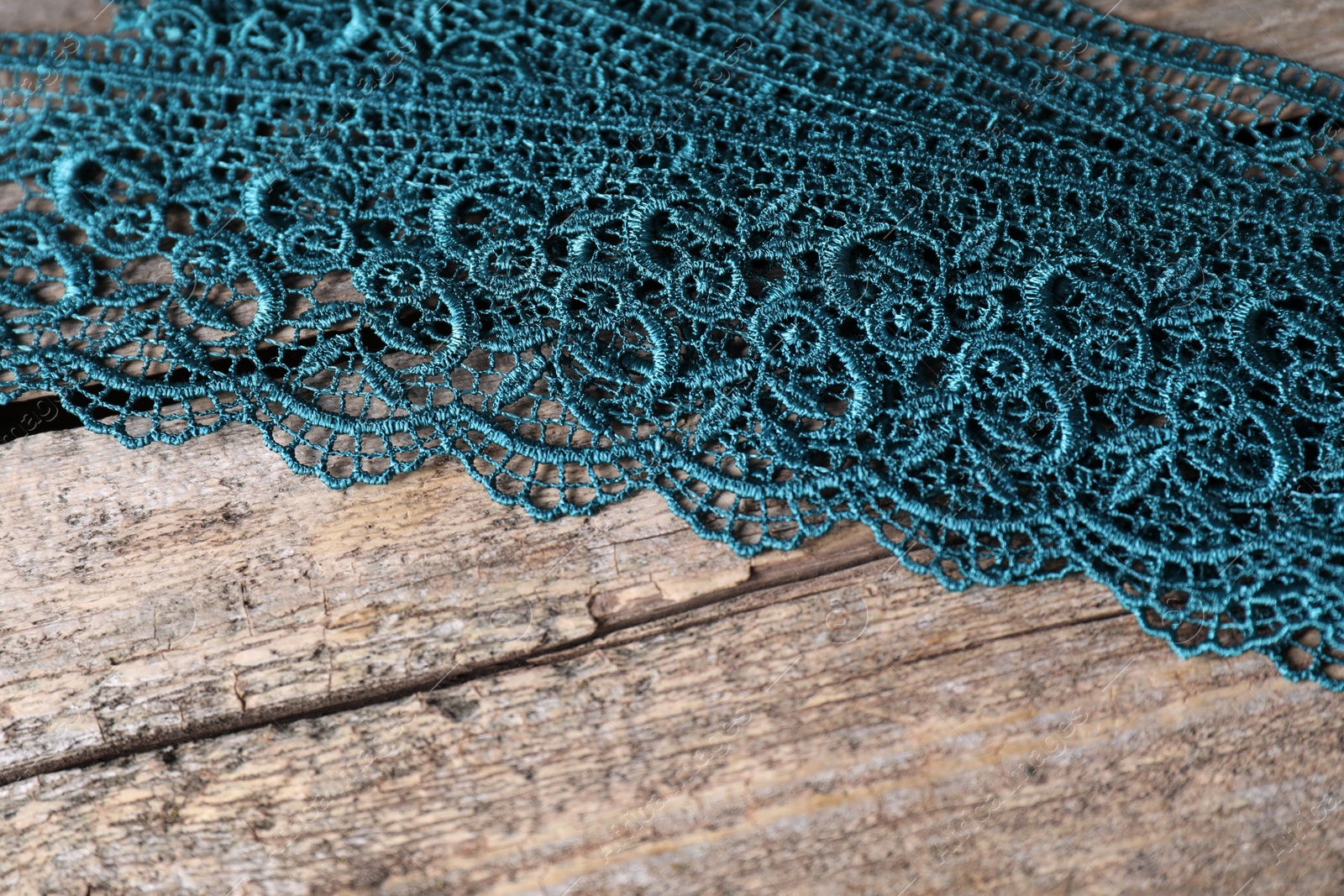 Photo of Beautiful lace on wooden table, above view