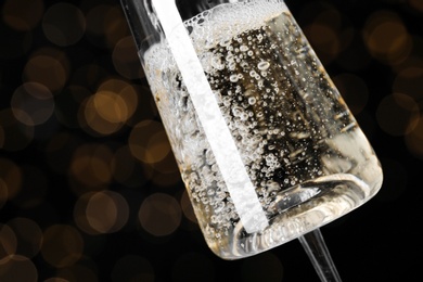 Glass of champagne against blurred lights, closeup