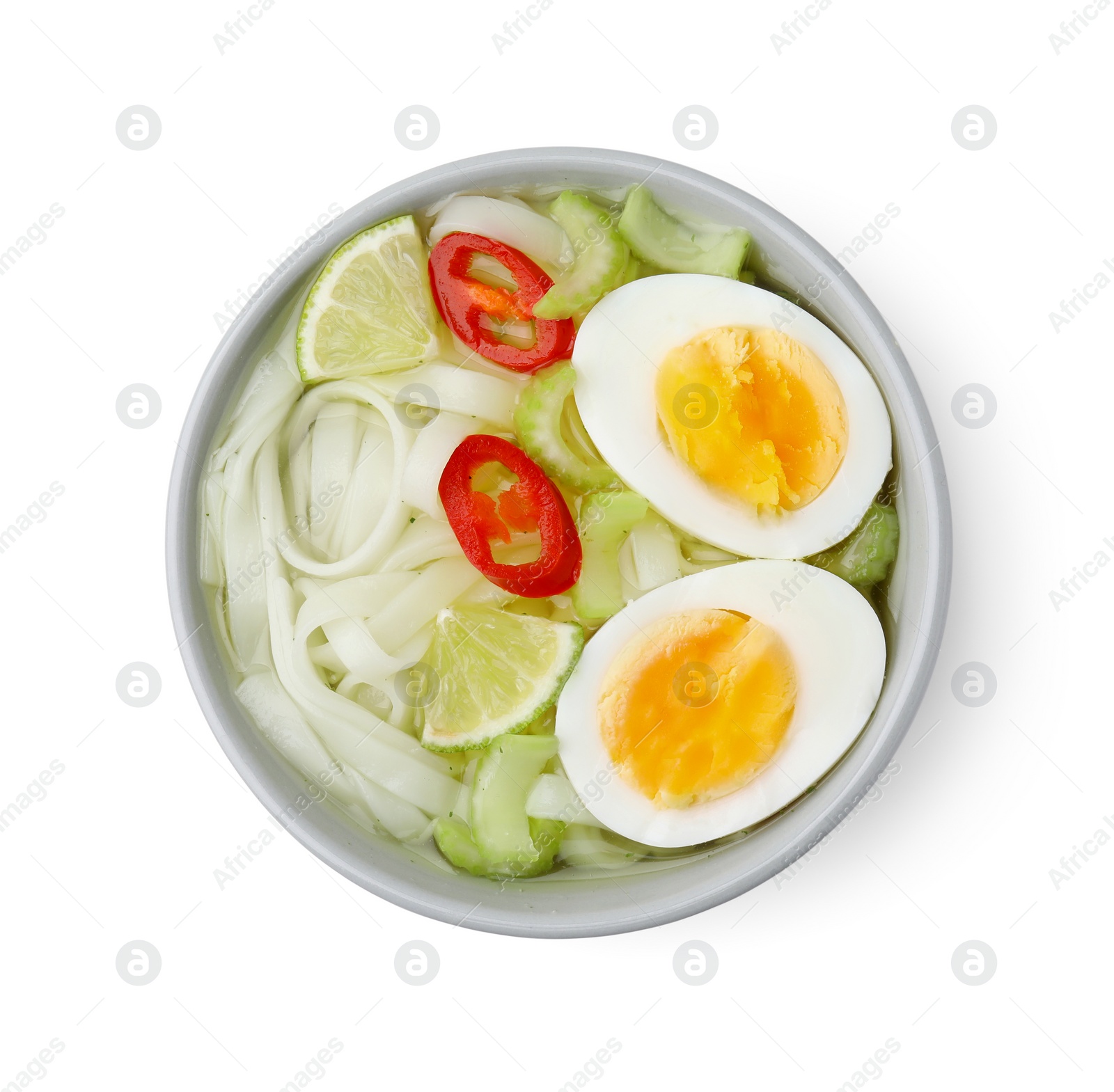 Photo of Bowl of delicious rice noodle soup with celery and egg isolated on white, top view