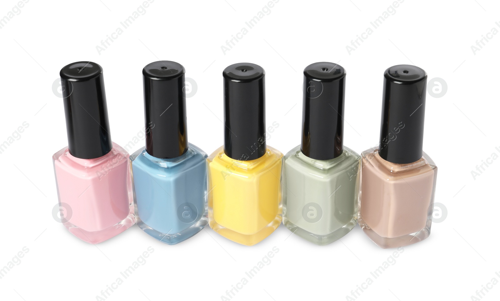 Photo of Pastel nail polishes in bottles isolated on white