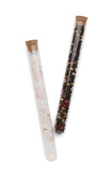 Photo of Glass tubes with pink himalayan salt and mixed peppercorns on white background, top view
