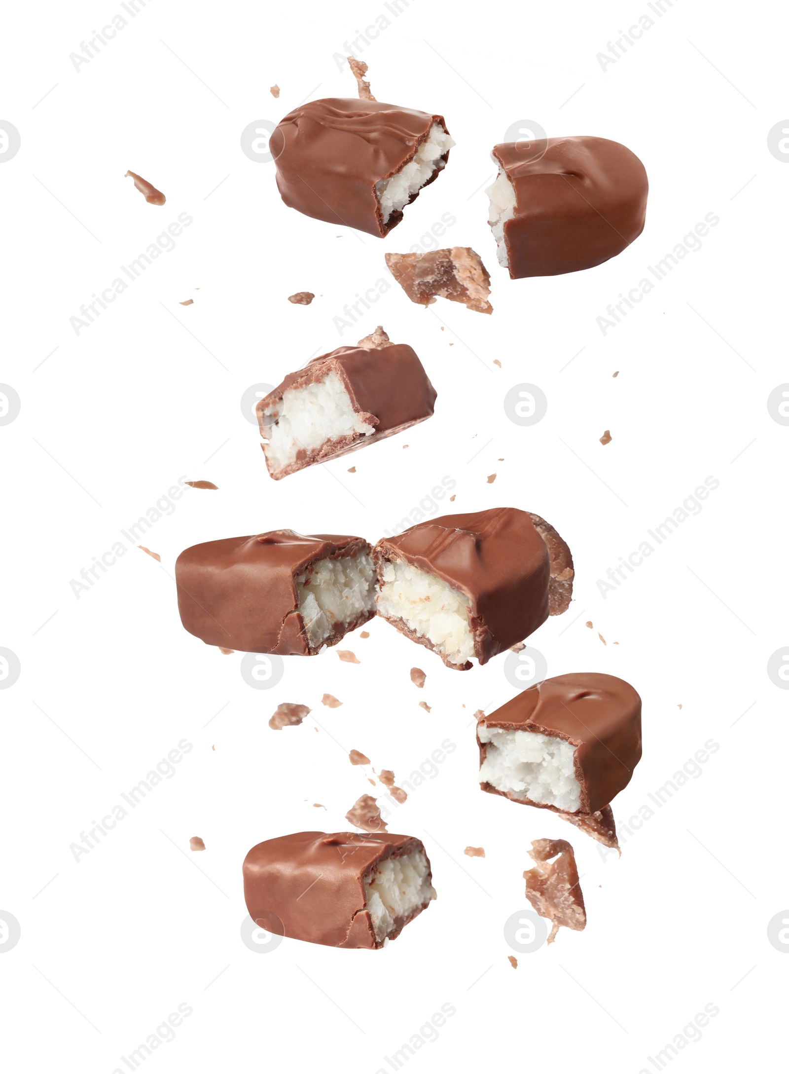 Image of Pieces of delicious chocolate bars with coconut filling falling on white background