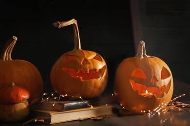 Photo of Halloween pumpkin heads. Jack lanterns on windowsill, view through glass