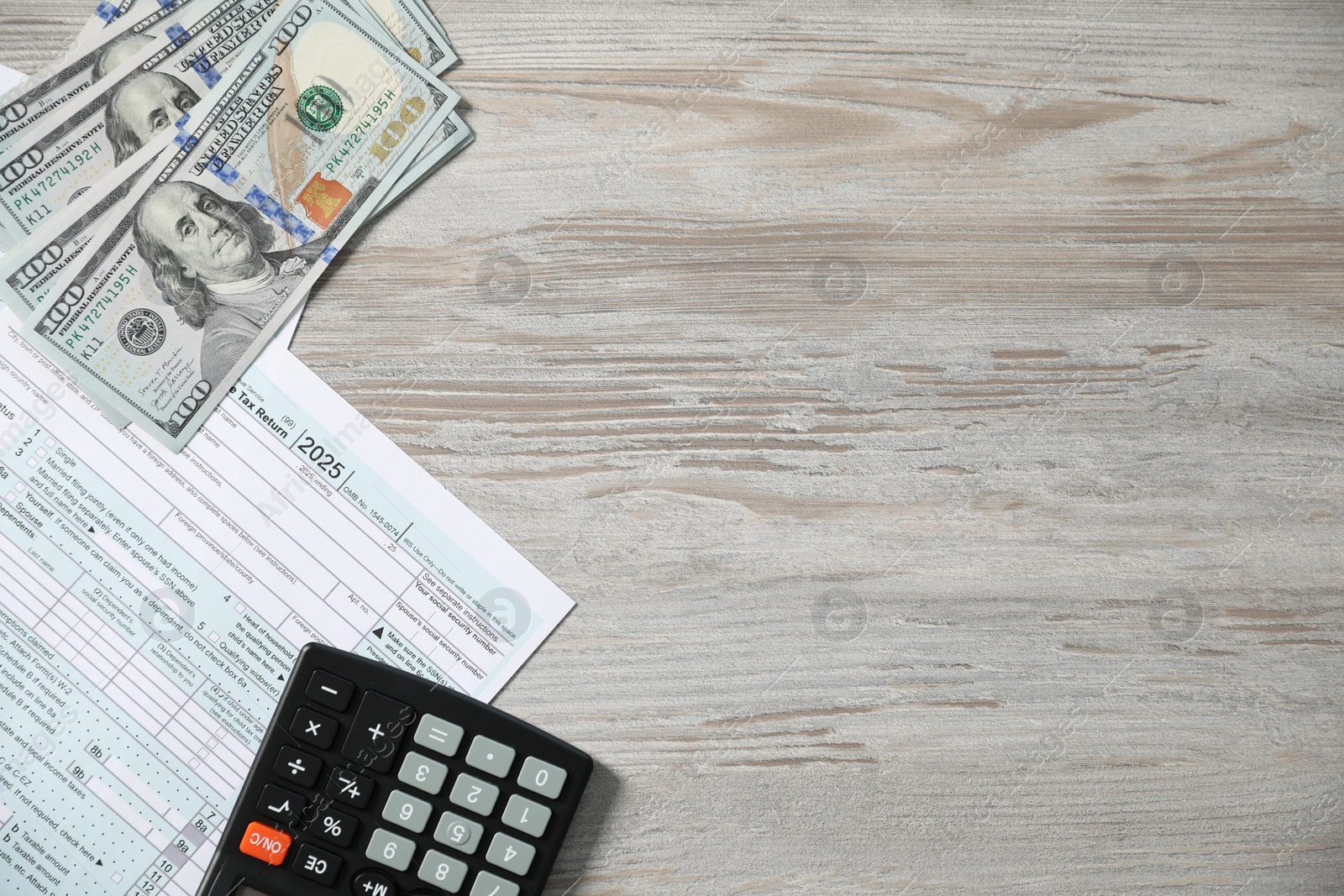 Photo of Payroll. Tax return forms, calculator and dollar banknotes on wooden table, flat lay. Space for text