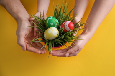 Photo of Family with composition of plant and Easter eggs on color background, top view