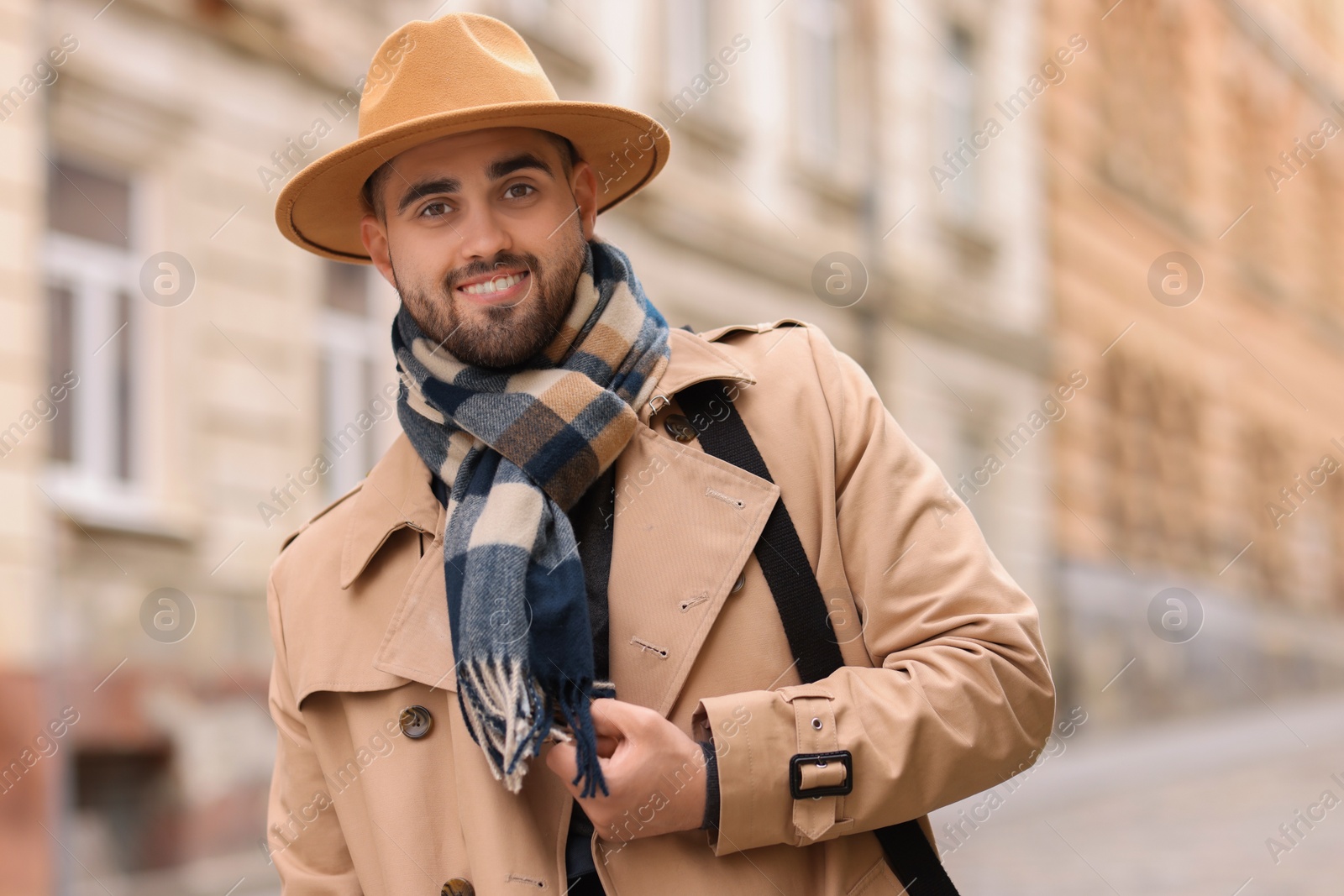 Photo of Smiling man in warm scarf on city street