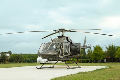 Photo of Beautiful modern helicopter on helipad in field