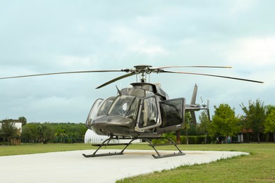 Beautiful modern helicopter on helipad in field