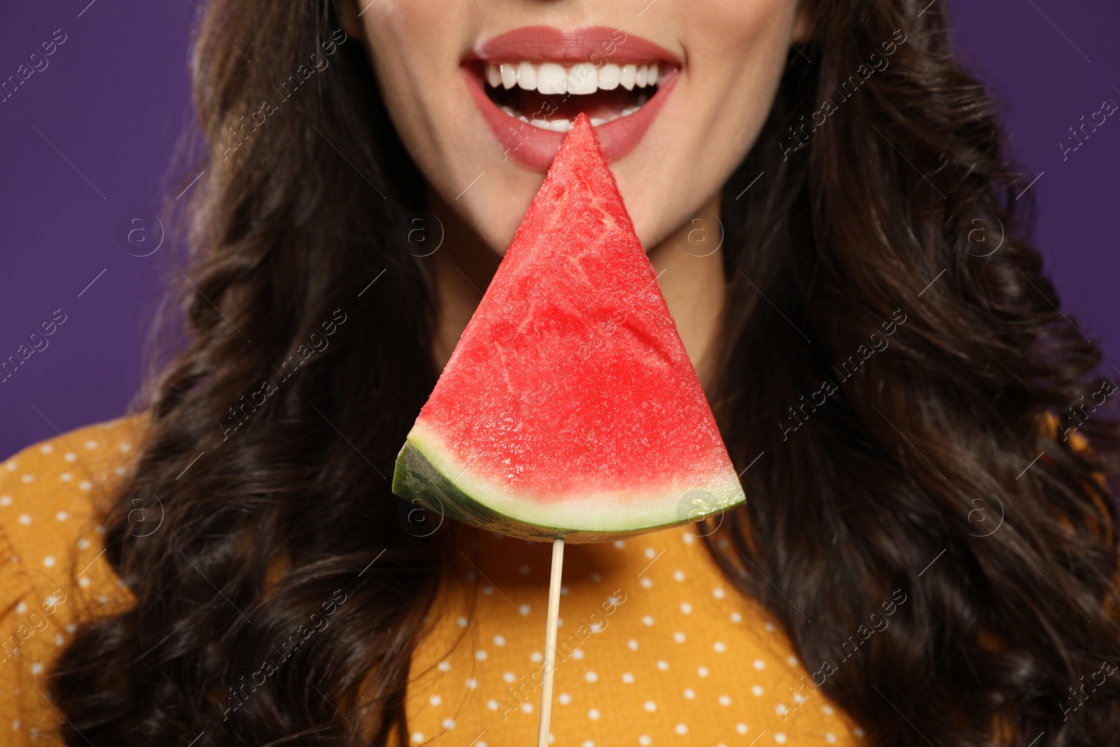 Photo of Beautiful young woman with watermelon on purple background, closeup