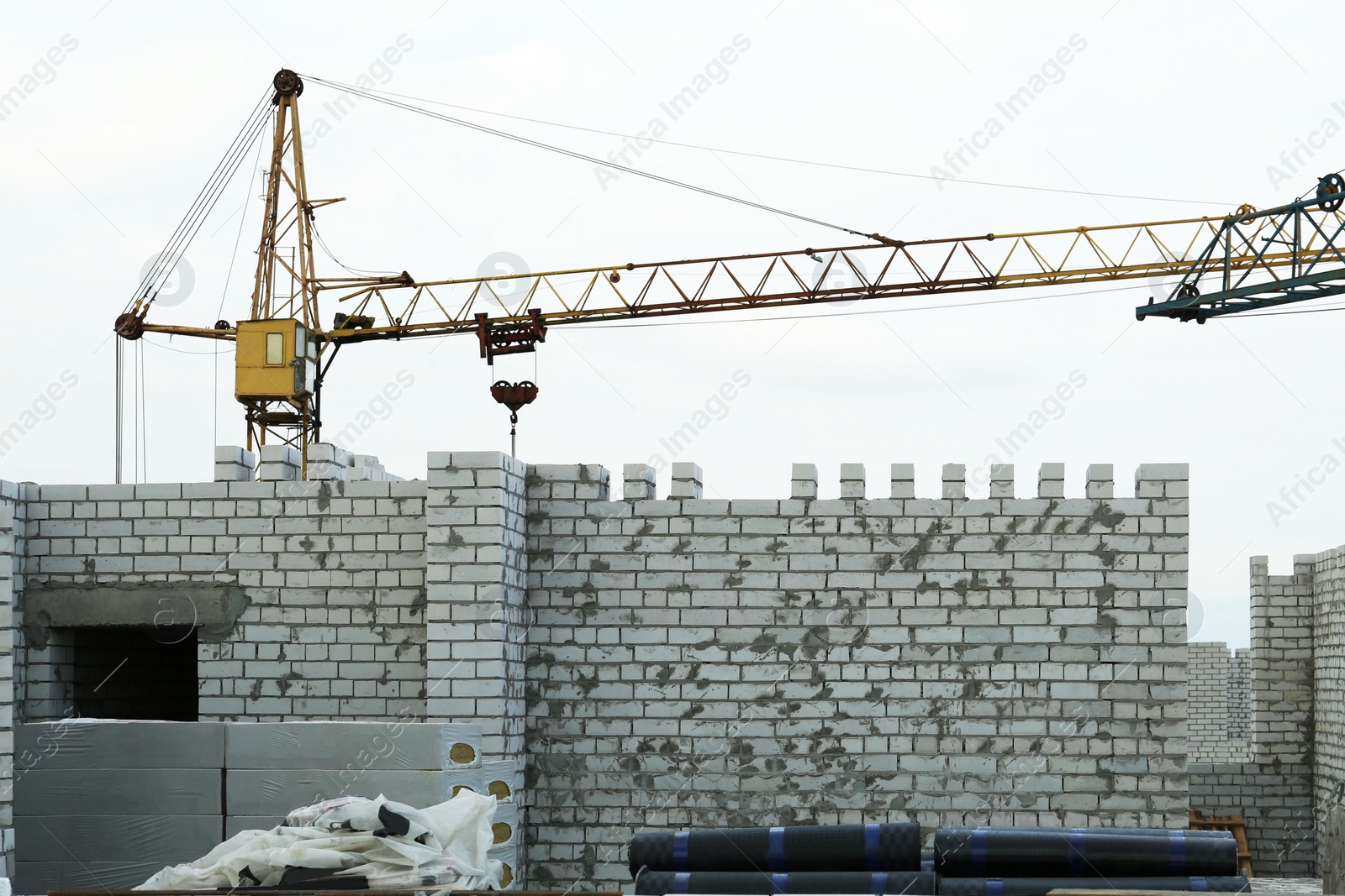 Photo of Construction site with tower crane near unfinished building