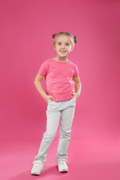 Cute little girl posing on pink background