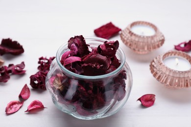 Aromatic potpourri of dried flowers in glass jar on white wooden table