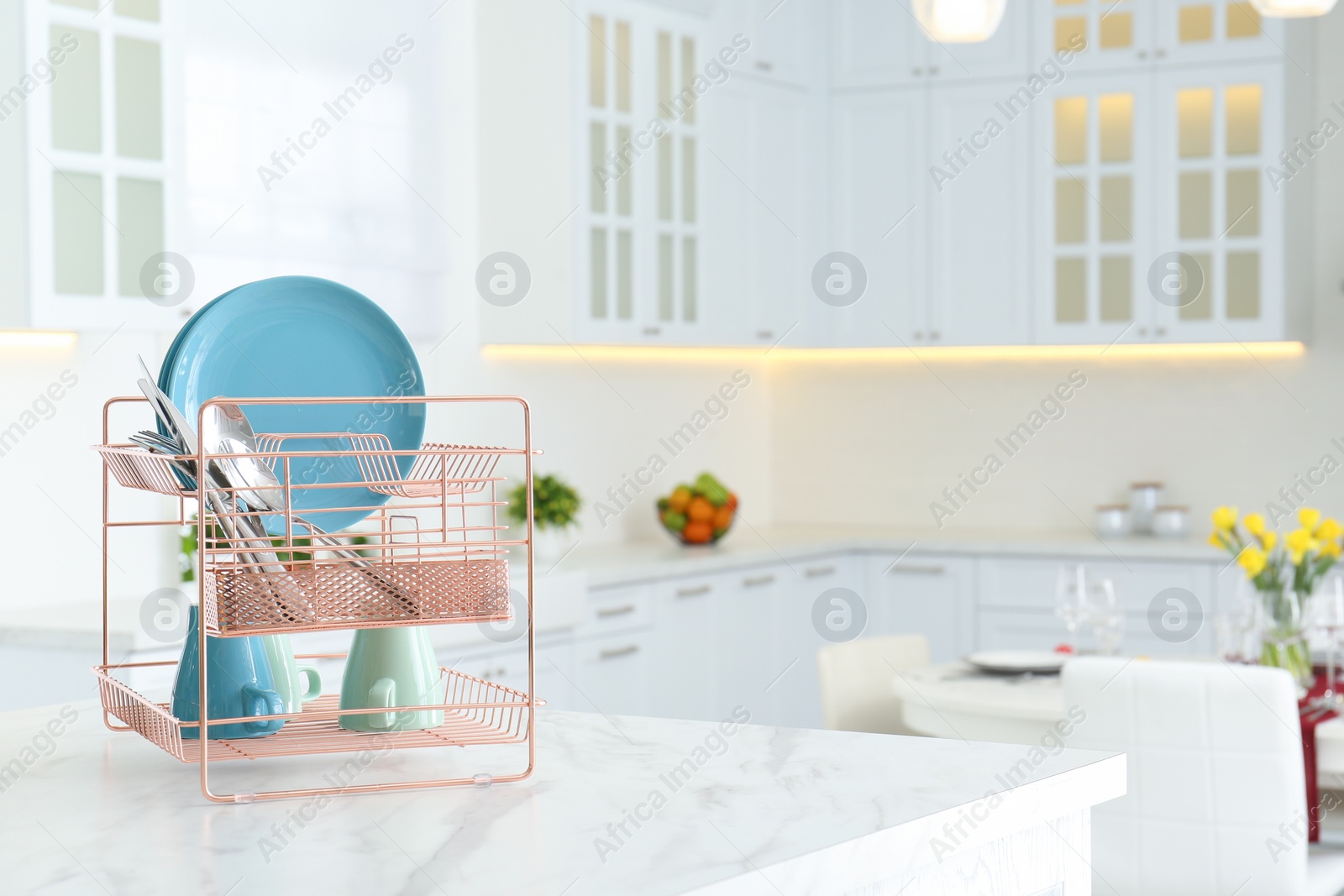 Photo of Clean dishes on drying rack in modern kitchen interior, space for text