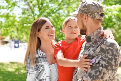 Photo of Male soldier with his family outdoors. Military service