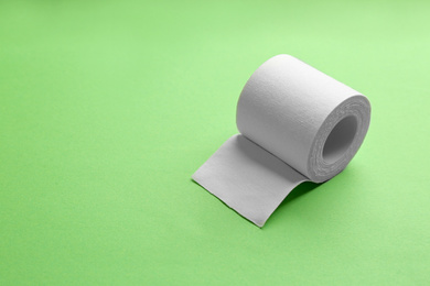Photo of Sticking plaster roll on green background. Space for text