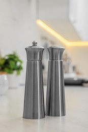 Stainless steel salt and pepper shakers on table