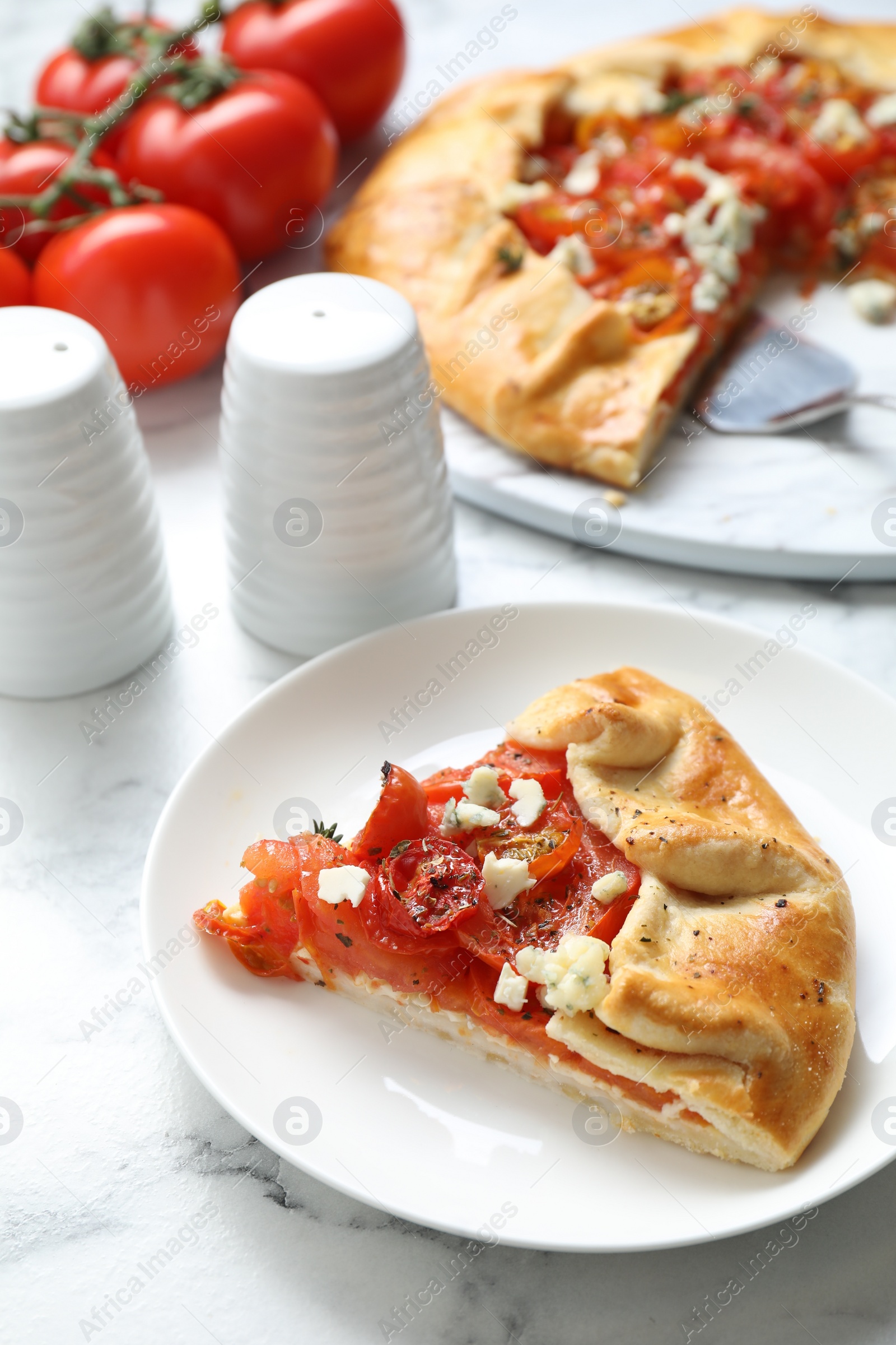 Photo of Tasty galette with tomato and cheese (Caprese galette) on white marble table, closeup