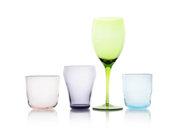 Photo of Set of colorful empty glasses on white background