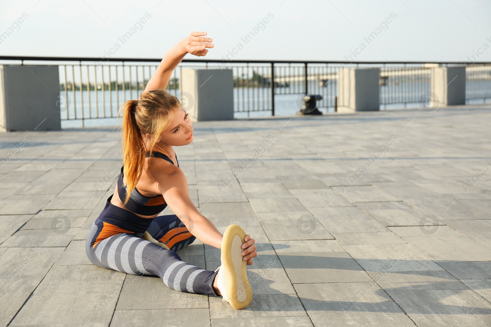 Photo of Beautiful woman in sportswear doing exercises outdoors on sunny day