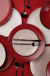 Stylish table setting with cutlery on red background, flat lay