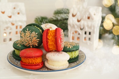 Different decorated Christmas macarons on white table, closeup