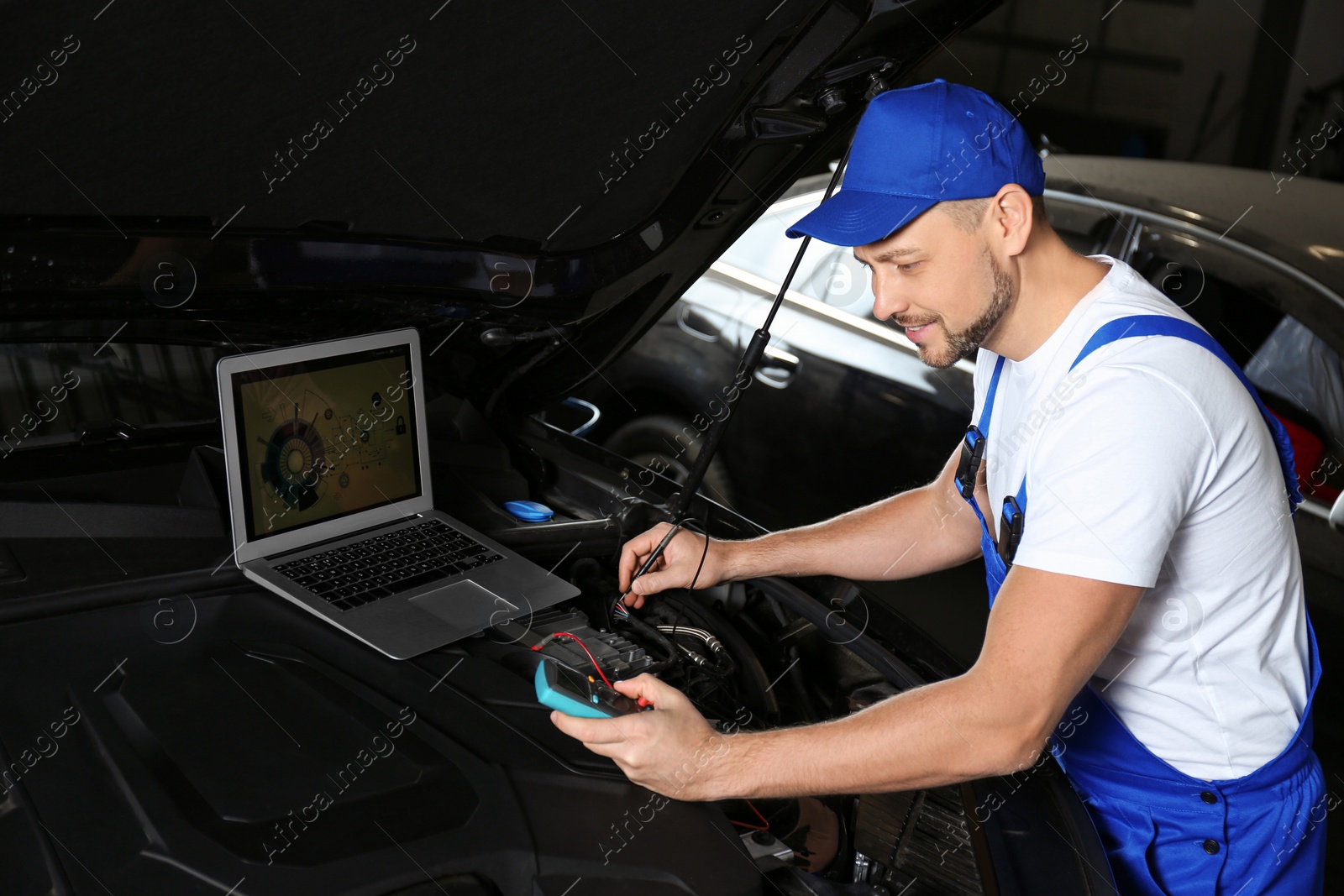 Photo of Mechanic with laptop doing car diagnostic at automobile repair shop