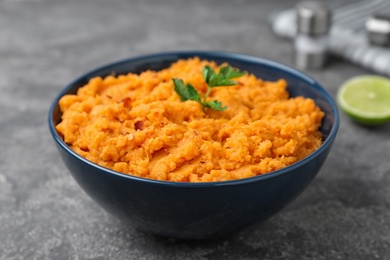 Bowl with mashed sweet potatoes on grey table