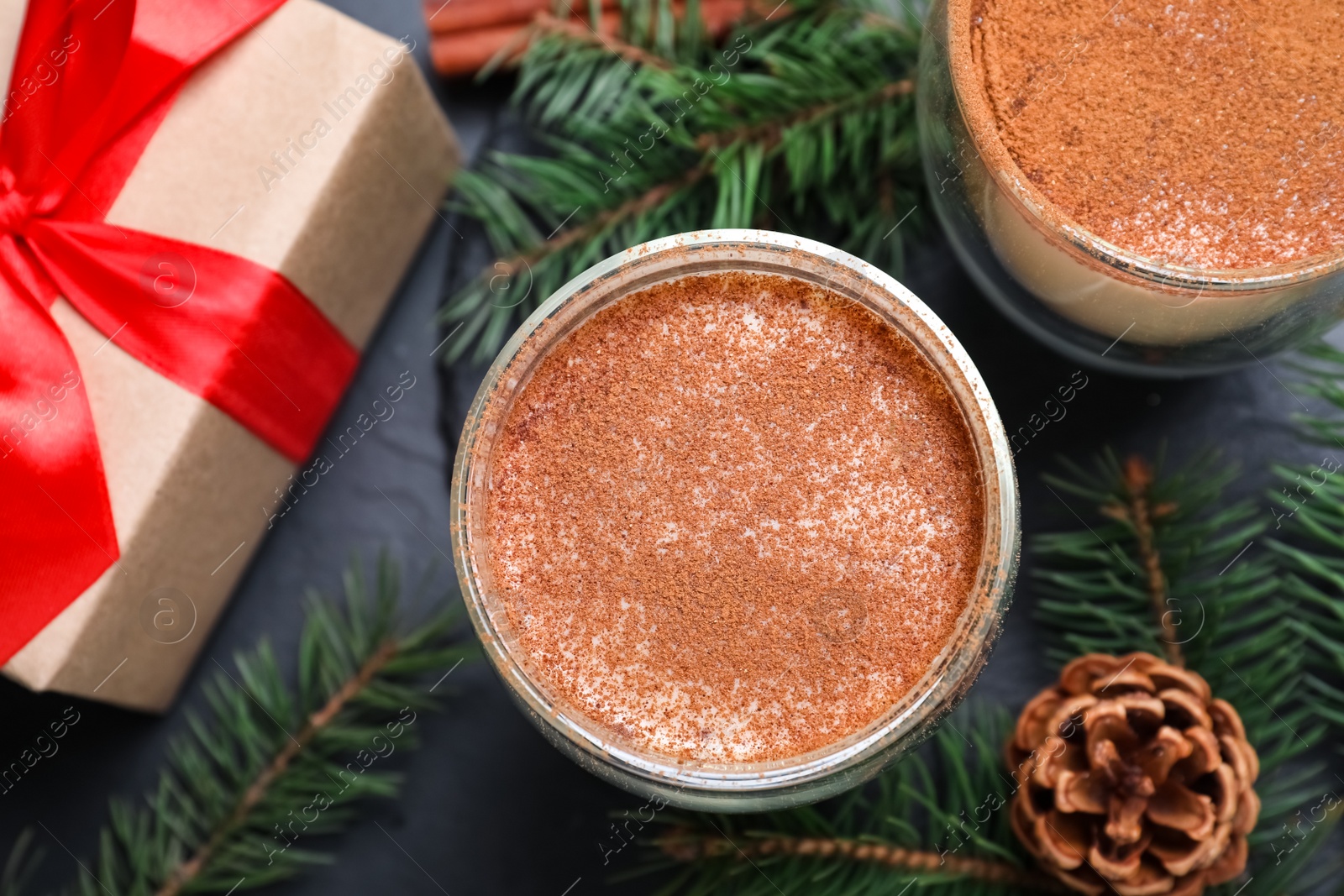 Photo of Delicious Christmas cocktail with liqueur on black table, flat lay