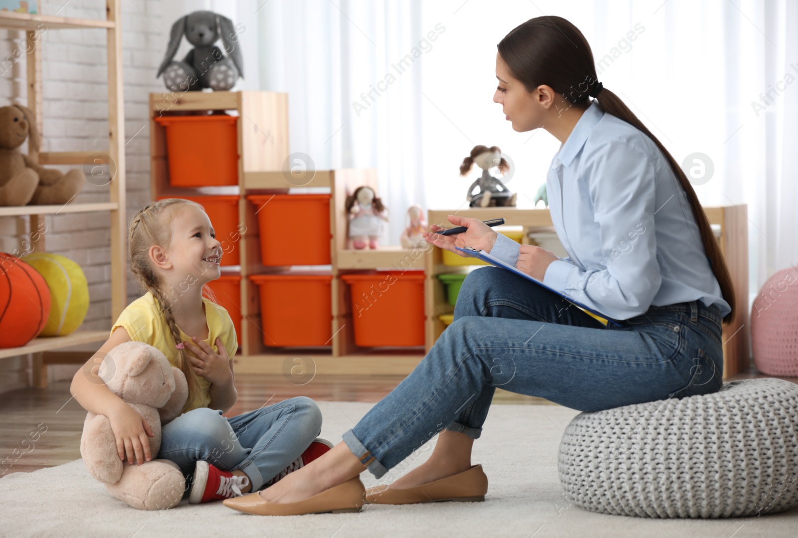 Photo of Child psychotherapist working with little girl in office