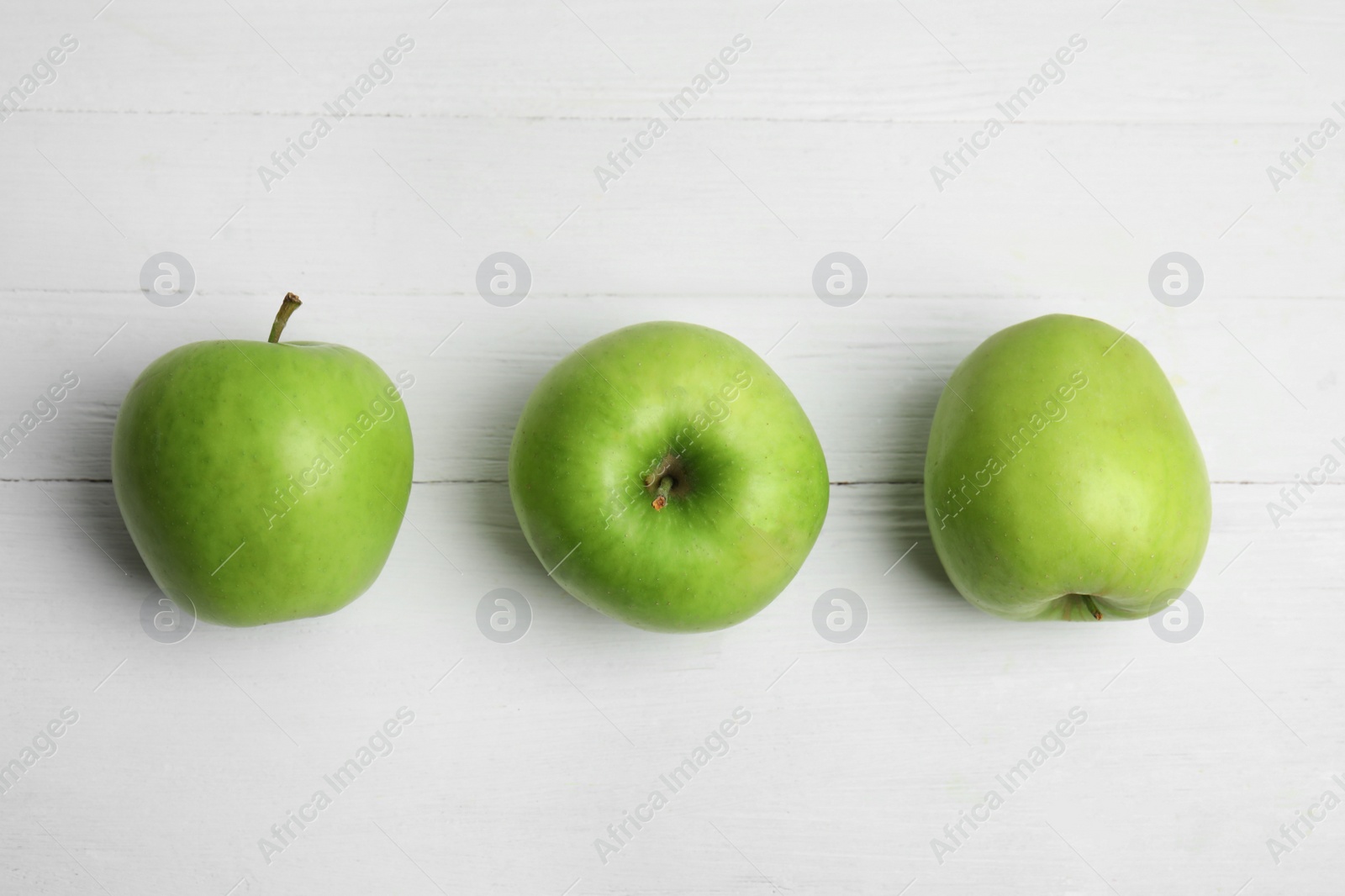 Photo of Ripe green apples on white wooden table, flat lay