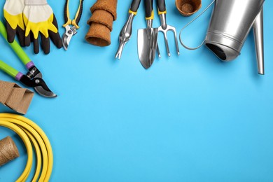 Flat lay composition with gardening tools on light blue background, space for text