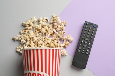 Photo of Modern tv remote control and popcorn on color background, flat lay