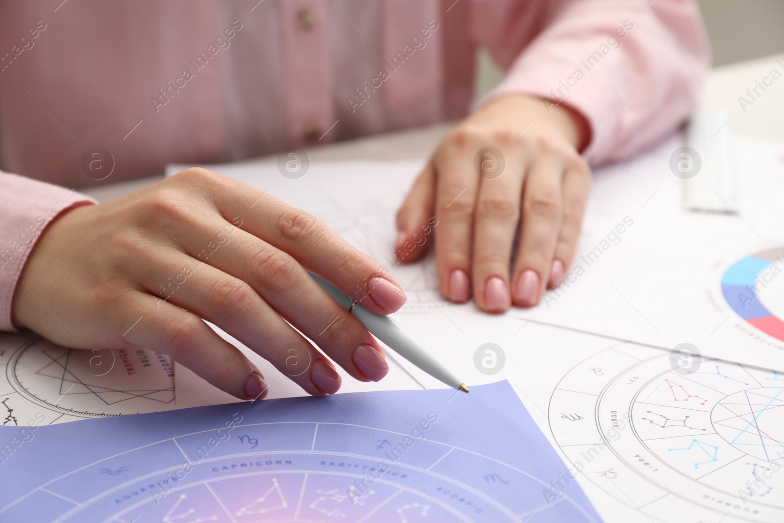 Photo of Astrologer using zodiac wheel for fate forecast at table, closeup. Fortune telling