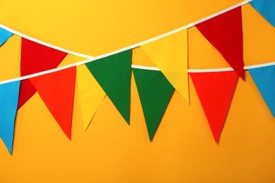 Photo of Buntings with colorful triangular flags on orange background