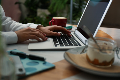 Photo of Blogger working with laptop in cafe, closeup