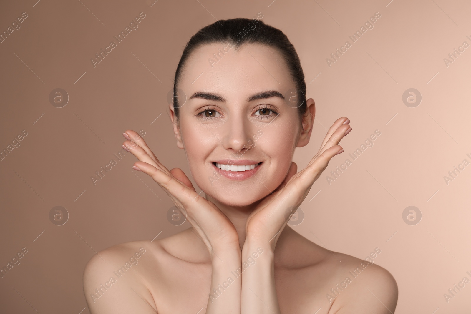 Photo of Portrait of beautiful young woman on light brown background