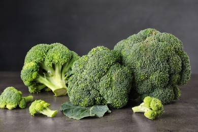 Photo of Fresh raw broccoli on grey table, closeup