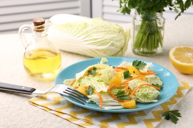 Photo of Tasty salad with Chinese cabbage, products and fork on beige table