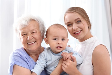 Happy young woman with her child and grandmother at home
