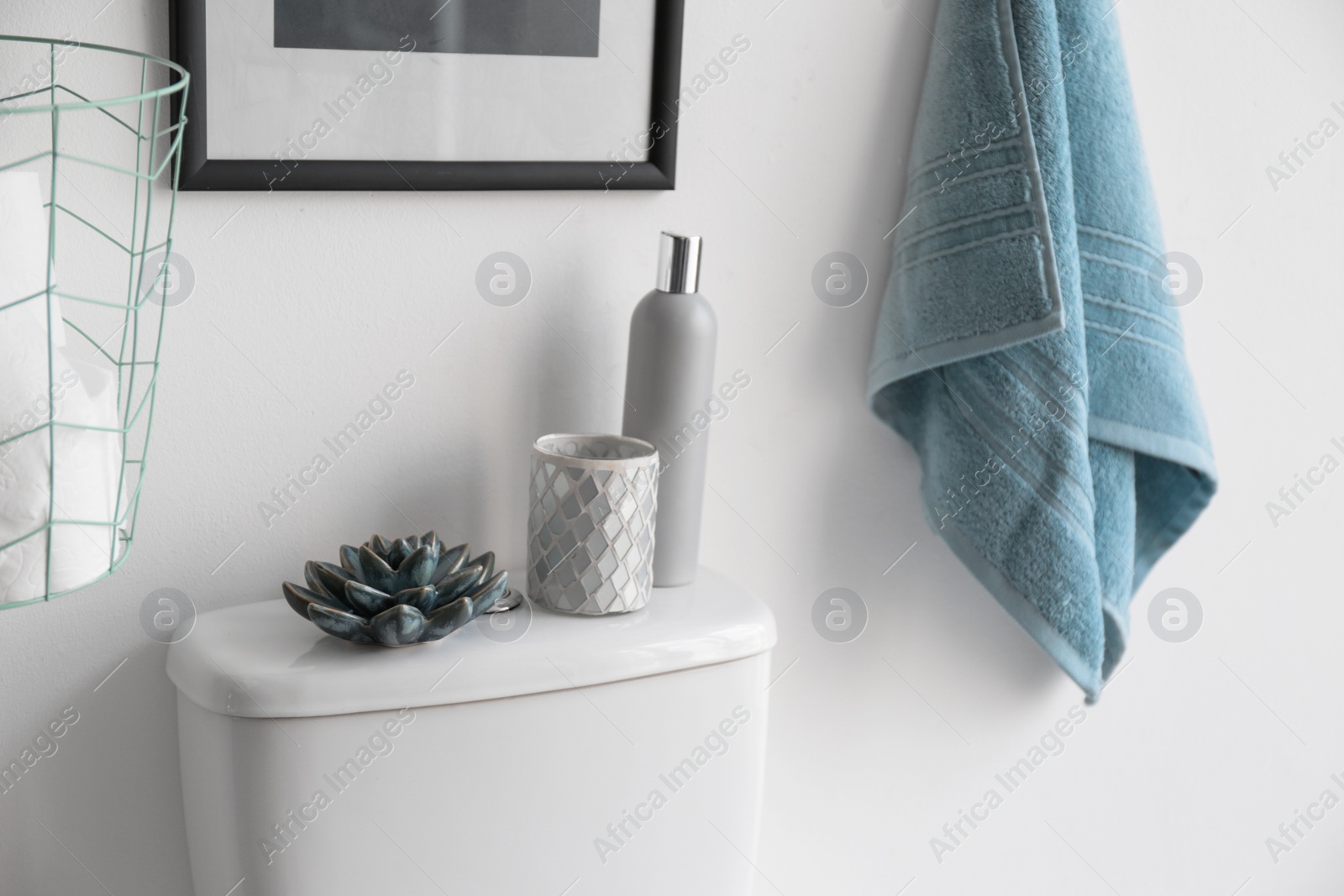 Photo of Decor elements, necessities and toilet bowl near white wall. Bathroom interior