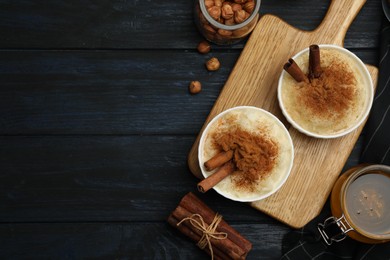 Photo of Delicious rice pudding with cinnamon on dark wooden table, flat lay. Space for text